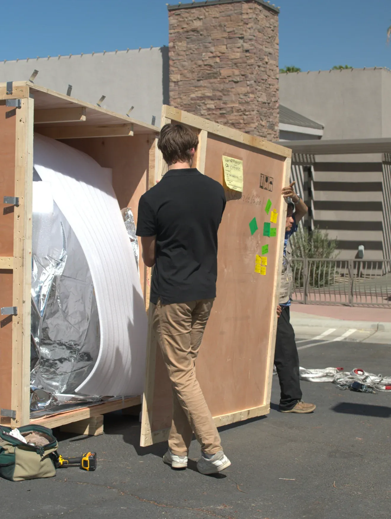 Our team opening a shipping crate outside a client site, the chamber wrapped in protective foam inside