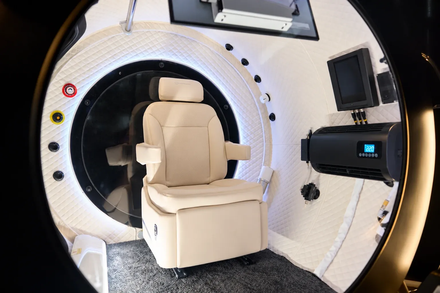 Inside the X: the cream leather seat, the control screen and the cooling unit under quilted white walls