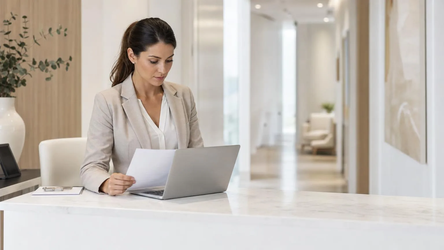 Clinic administrator reviewing billing paperwork at a clean, bright front desk